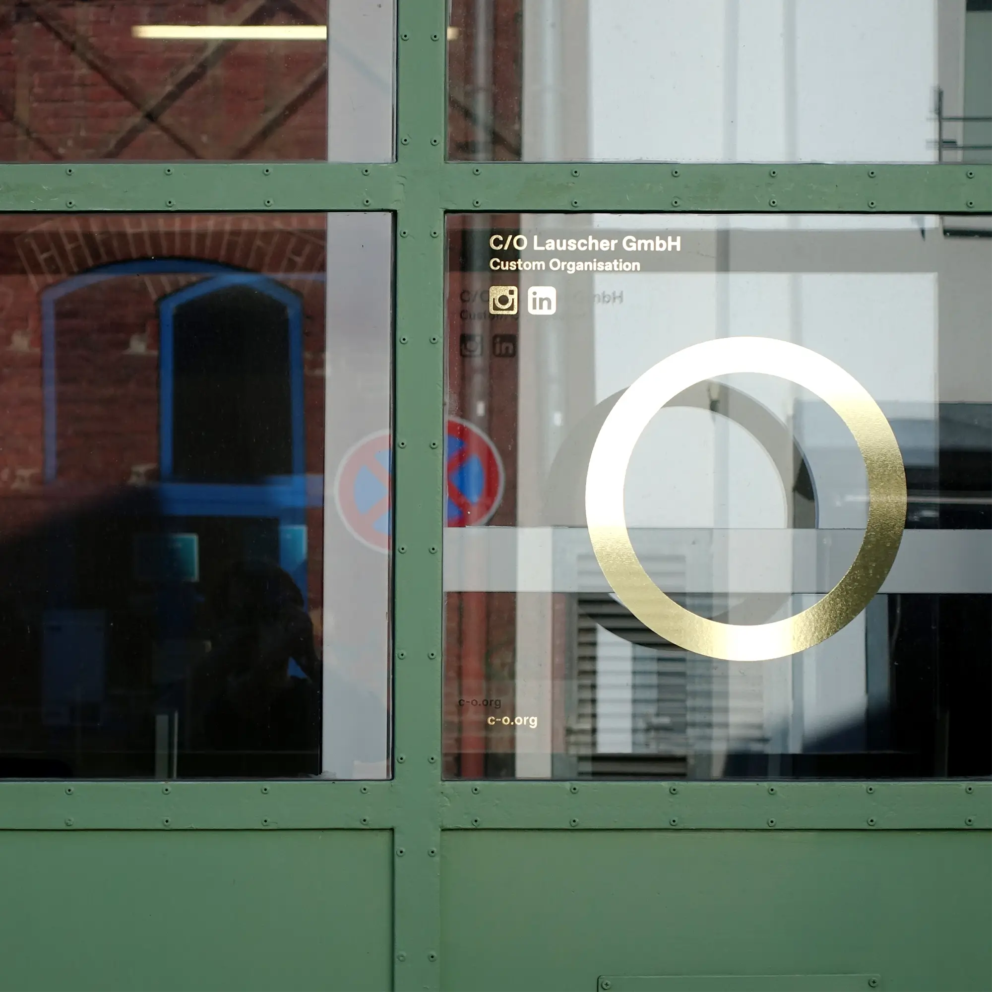 Closeup of the entrance gate of C/O Lauscher GmbH with its Logo.