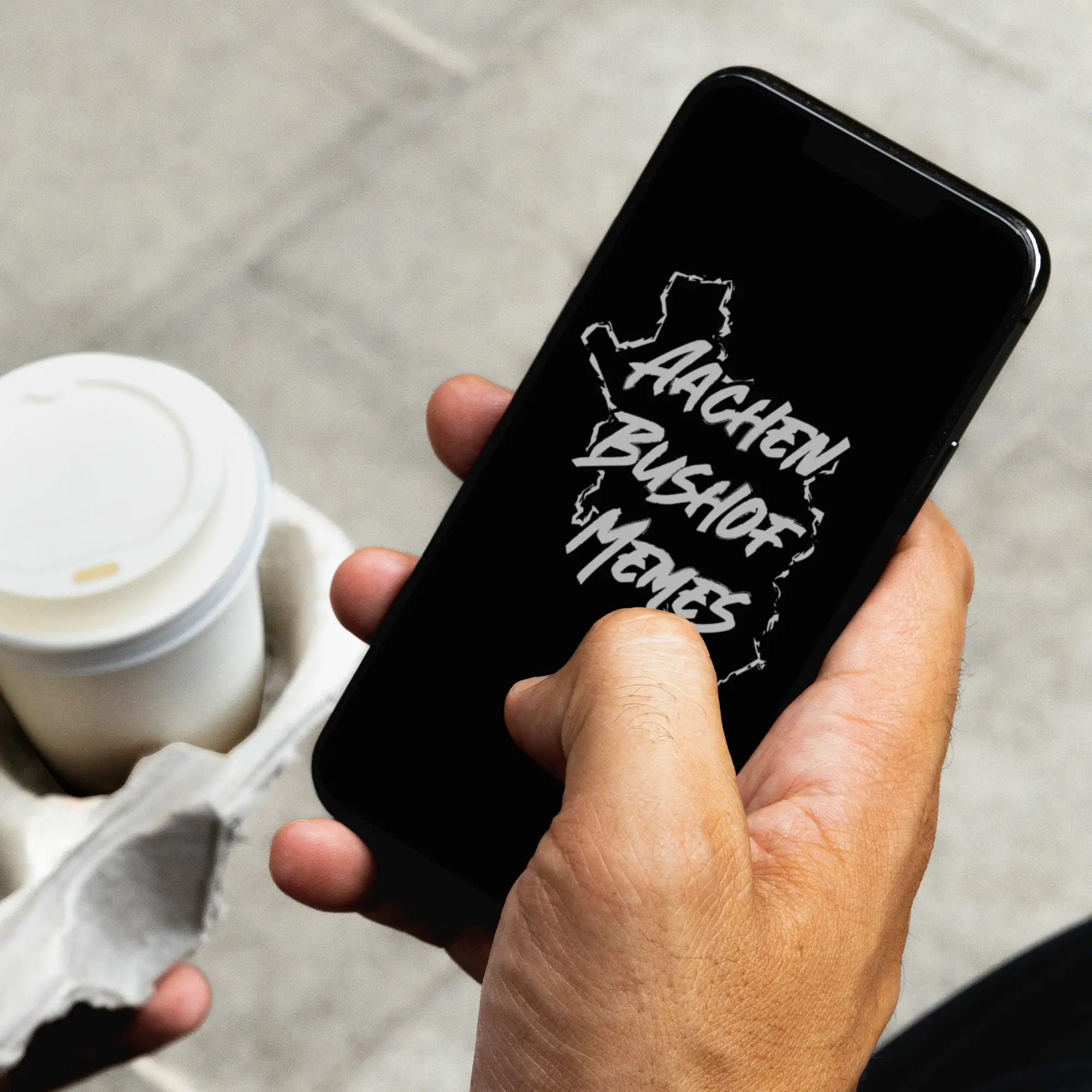 Holding a smartphone in hand, the logo of the Instagram channel Aachen Bushof Memes.